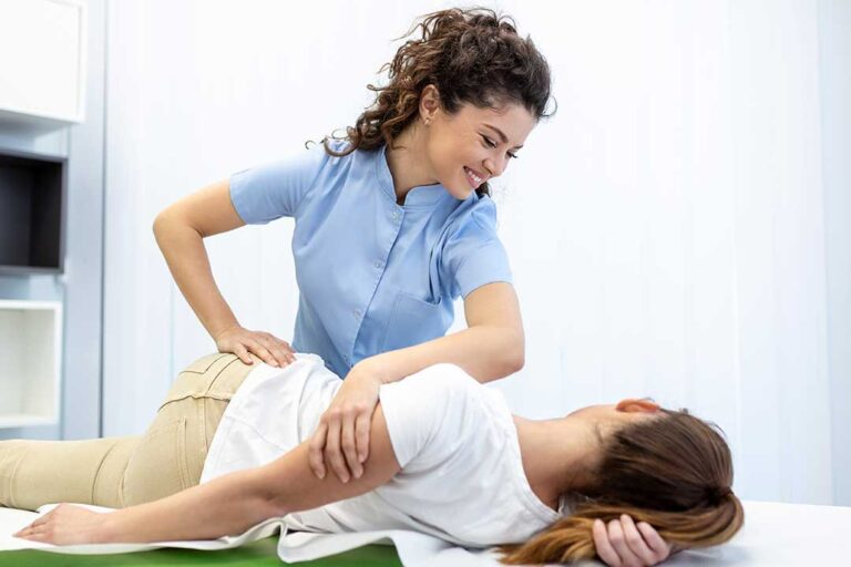An older adult gently stretching their legs in a sunlit living room with a yoga mat and comfortable furnishings.